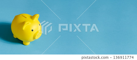 Yellow piggy bank on a bright blue background finance concept Yellow piggy bank on a bright blue background finance concept 136911774