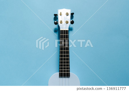Light blue soprano ukulele on a matching blue banner background flat lay Light blue soprano ukulele on a matching blue banner background flat lay 136911777