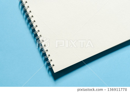Blank spiral sketchbook on a bright blue background - top view Blank spiral sketchbook on a bright blue background - top view 136911778