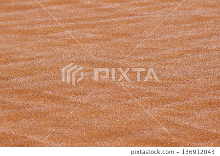Perfectly parallel ridges on a sandy surface create a rigid mathematical rhythm. A clean architectural background for premium design 136912043