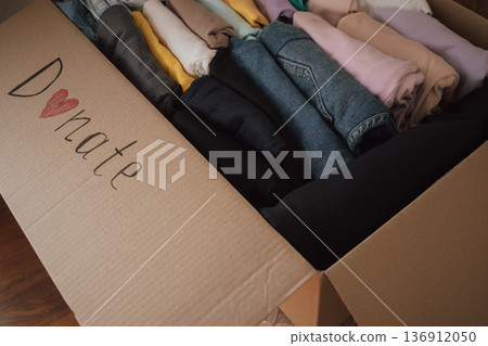 Box filled with neatly folded clothes ready for donation at a local charity for those in need Box filled with neatly folded clothes ready for donation at a local charity for those in need 136912050
