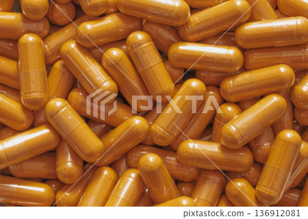 Minimal top-down flatlay with bright curcumin capsules scattered on white marble, highlighting vibrant wellness aesthetics and clean modern style 136912081