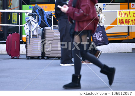 日本東京的城市景觀，入境旅遊仍在繼續……行李箱……父親看著母親和女兒放下行李後前往某處——澀谷 136912097