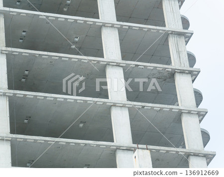 Concrete frame of a building column with floor slabs during construction. Modern architecture development for urban project. Concrete frame of a building column with floor slabs during construction. Modern architecture development for urban project. 136912669