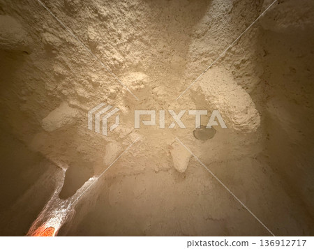 Salt cave ceiling with textured mineral formations and warm backlight. Natural therapy environment, breathing wellness and calming interior atmosphere Salt cave ceiling with textured mineral formations and warm backlight. Natural therapy environment, breathing wellness and calming interior atmosphere 136912717