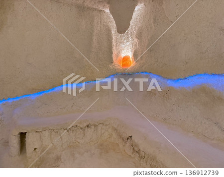 Salt therapy cave interior with glowing mineral wall and benches. Respiratory wellness, immune support and natural health treatment 136912739