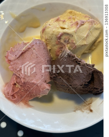 A bowl with three scoops of ice cream: raspberry, chocolate, and vanilla flavors A bowl with three scoops of ice cream: raspberry, chocolate, and vanilla flavors 136913308
