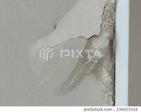 Peeling paint on a damaged wall with visible cracks and mold texture, conceptual background 136913328