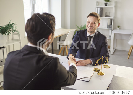 Professional lawyer makes hand shake gesture with client Professional lawyer makes hand shake gesture with client 136913697