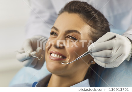 Healthy beautiful smile of woman with white teeth at dental checkup with mirror 136913701