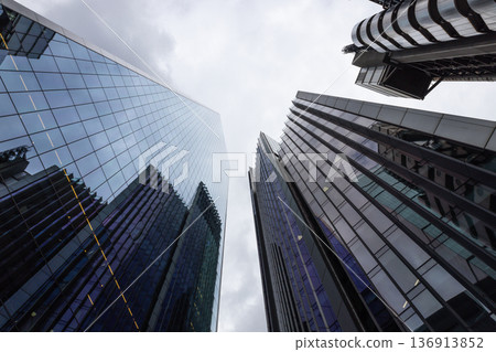 Modern skyscrapers towering into a cloudy sky in a financial district 136913852