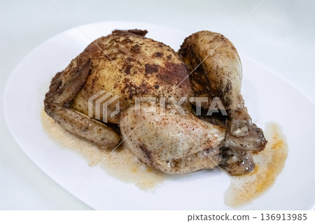 Roast chicken on white plate. Cooked poultry for dinner meal. Traditional christmas food background. Delicious roasted whole bird. Roast chicken on white plate. Cooked poultry for dinner meal. Traditional christmas food background. Delicious roasted whole bird. 136913985