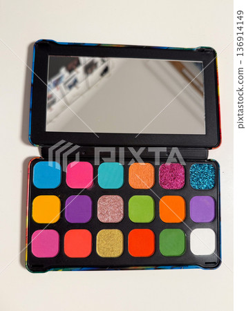 Colorful eyeshadow palette with mirror and vibrant pigments. Makeup artistry, beauty creativity, cosmetic product display, and self expression concept 136914149
