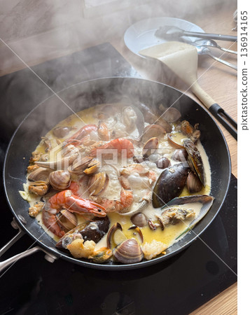 Seafood stew with mussel clam shrimp and creamy broth in pan. Mediterranean cuisine, home gastronomy, nourishment ritual, and comfort food concept Seafood stew with mussel clam shrimp and creamy broth in pan. Mediterranean cuisine, home gastronomy, nourishment ritual, and comfort food concept 136914165