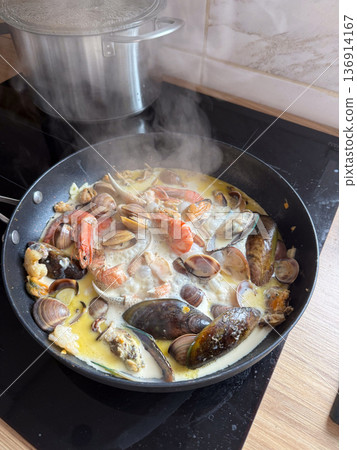 Seafood stew with mussel clam shrimp and creamy broth in pan. Mediterranean cuisine, home gastronomy, nourishment ritual, and comfort food concept 136914167