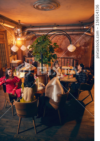Retro women gathered around cafe tables in warm brick restaurant. Retro women gathered around cafe tables in warm brick restaurant. 136914336