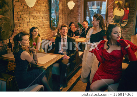 Retro inspired group enjoying cocktails in brick wall lounge setting Retro inspired group enjoying cocktails in brick wall lounge setting 136914365