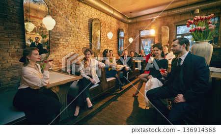Retro dressed friends relaxing with cocktails in cozy brick lounge. Retro dressed friends relaxing with cocktails in cozy brick lounge. 136914368