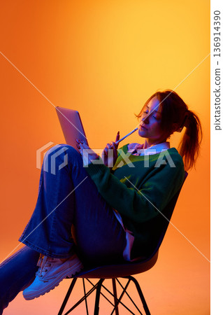 Creative professional sketching ideas on tablet in studio with vibrant gradient lighting. Creative professional sketching ideas on tablet in studio with vibrant gradient lighting. 136914390