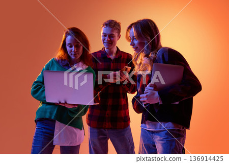 Corporate team comparing data across laptop and smartphone devices. Corporate team comparing data across laptop and smartphone devices. 136914425