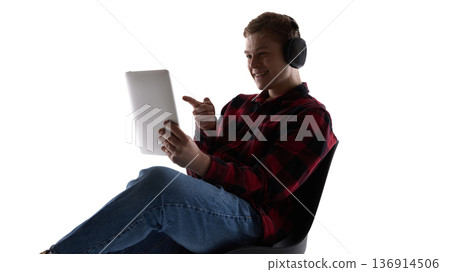 Young man wearing headphones using tablet isolated on white background. 136914506