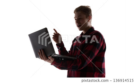 Young man pointing at laptop screen isolated on white background. Young man pointing at laptop screen isolated on white background. 136914515