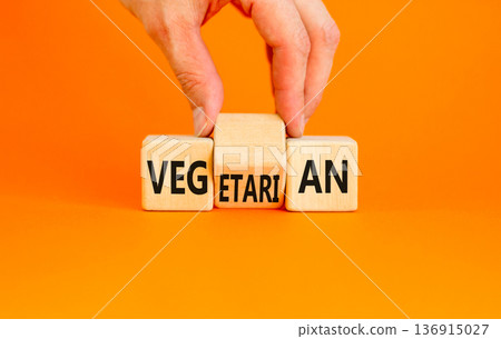 Vegetarian or vegan symbol. Concept words Vegetarian Vegan on wooden block. Beautiful orange table orange background. Vegan hand. Healthy lifestyle vegetarian or vegan concept. Copy space. Vegetarian or vegan symbol. Concept words Vegetarian Vegan on wooden block. Beautiful orange table orange background. Vegan hand. Healthy lifestyle vegetarian or vegan concept. Copy space. 136915027