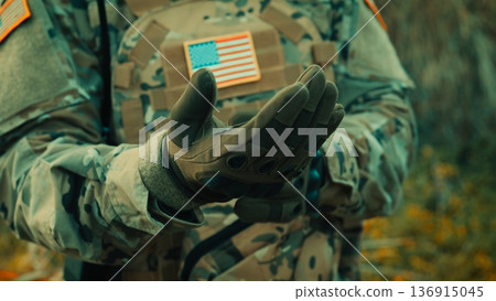 US Soldier Wearing Protective Gloves Before Going To War 136915045