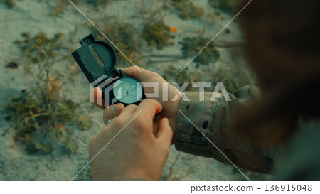 Soldier hand man checks compass in isolated desert Soldier hand man checks compass in isolated desert 136915048