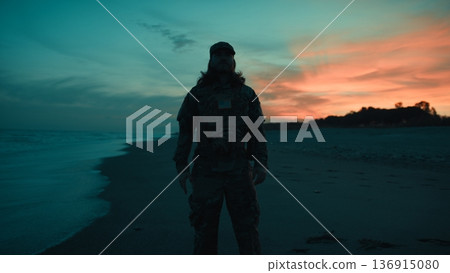 Silhouette of an American soldier salutes on beach sunset during Veterans Day Silhouette of an American soldier salutes on beach sunset during Veterans Day 136915080