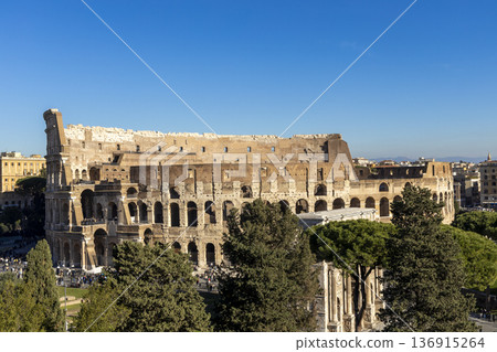 Famous Coliseum in Rome. Colosseum, or Coliseum. Sunset at huge Roman amphitheatre, Rome, Italy, Europe. Famous touristic place in the world and Europe. Beautiful blue sky background. Famous Coliseum in Rome. Colosseum, or Coliseum. Sunset at huge Roman amphitheatre, Rome, Italy, Europe. Famous touristic place in the world and Europe. Beautiful blue sky background. 136915264