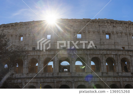 Famous Coliseum in Rome. Colosseum, or Coliseum. Sunset at huge Roman amphitheatre, Rome, Italy, Europe. Famous touristic place in the world and Europe. Beautiful blue sky background. 136915268