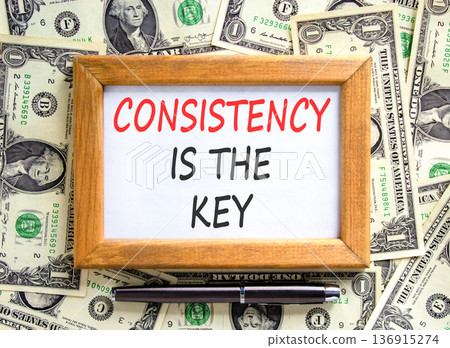 Consistency is the key symbol. Concept words Consistency is the key on beautiful wooden picture frame. Beautiful dollar bills background. Business consistency is the key concept. Copy space. 136915274