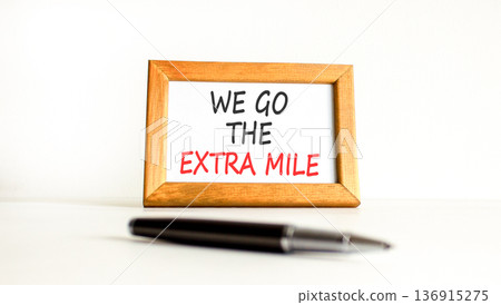Support, help we go the extra mile symbol. Concept words We go the extra mile on beautiful wooden picture frame. Beautiful white background. Business we go the extra mile concept. Copy space. Support, help we go the extra mile symbol. Concept words We go the extra mile on beautiful wooden picture frame. Beautiful white background. Business we go the extra mile concept. Copy space. 136915275
