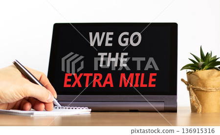 Support, help we go the extra mile symbol. Concept words We go the extra mile on beautiful tablet. Beautiful white background. Businessman's hand. Business we go the extra mile concept. Copy space. Support, help we go the extra mile symbol. Concept words We go the extra mile on beautiful tablet. Beautiful white background. Businessman's hand. Business we go the extra mile concept. Copy space. 136915316