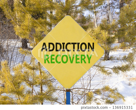 Addiction recovery symbol. Concept words Addiction recovery on beautiful yellow road sign. Beautiful winter forest background. Psychology addiction recovery concept. Copy space. Addiction recovery symbol. Concept words Addiction recovery on beautiful yellow road sign. Beautiful winter forest background. Psychology addiction recovery concept. Copy space. 136915331