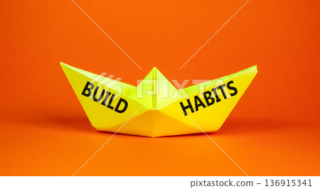 Build habits symbol. Concept word Build habits on beautiful yellow paper boat. Beautiful orange paper background. Business build habits concept. Copy space. 136915341