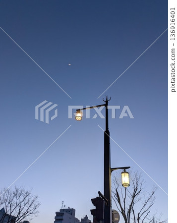 Street lights and crescent moon in the twilight sky Street lights and crescent moon in the twilight sky 136916401