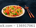Chow Mein noodles with chicken and vegetables, on a black background 136917061