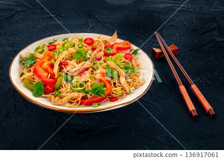 Chow Mein noodles with chicken and vegetables, on a black background 136917061