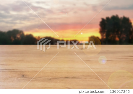 Empty wooden table with Blurred sunset sky on background. Natural wood surface presentation for product display. Concept of outdoor advertising. Empty wooden table with Blurred sunset sky on background. Natural wood surface presentation for product display. Concept of outdoor advertising. 136917245