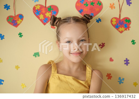 Portrait of smiling girl with colorful puzzle glasses on yellow background. Concept of autism awareness, neurodiversity, inclusion, sensory perception and support for children with autism disorder. Portrait of smiling girl with colorful puzzle glasses on yellow background. Concept of autism awareness, neurodiversity, inclusion, sensory perception and support for children with autism disorder. 136917432