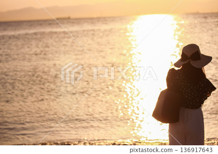 Silhouette of a woman looking at the sea Silhouette of a woman looking at the sea 136917643