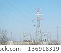 High voltage electrical power line tower and substation against a clear sky. Energy transmission infrastructure for electricity supply. 136918319