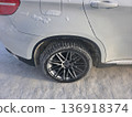 Car with winter tire and alloys on a snowy road showing the effect of cold weather for automotive and transportation topic. 136918374
