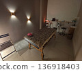 Empty massage table in a dimly lit spa room, designed for relaxation and therapeutic bodywork. Interior of a wellness center for professional healing. 136918403