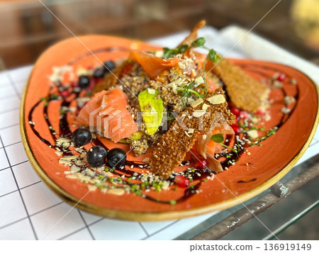 Quinoa salad with salmon, avocado and berries on ceramic plate. Healthy cuisine, balanced nutrition, gourmet presentation, modern gastronomy concept Quinoa salad with salmon, avocado and berries on ceramic plate. Healthy cuisine, balanced nutrition, gourmet presentation, modern gastronomy concept 136919149