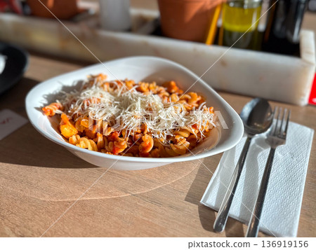 Fusilli pasta with tomato sauce and parmesan on table. Italian cuisine, comfort food, casual dining, everyday meal concept Fusilli pasta with tomato sauce and parmesan on table. Italian cuisine, comfort food, casual dining, everyday meal concept 136919156