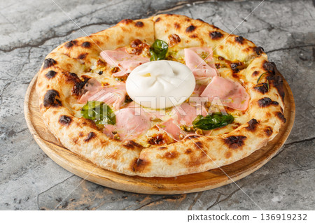 Mortadella and burrata pizza with basil and pistachios close-up on a wooden board. Horizontal Mortadella and burrata pizza with basil and pistachios close-up on a wooden board. Horizontal 136919232