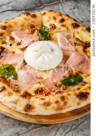 Charred pizza with mortadella sausage and burrata cheese close-up on a wooden board. Vertical Charred pizza with mortadella sausage and burrata cheese close-up on a wooden board. Vertical 136919236
